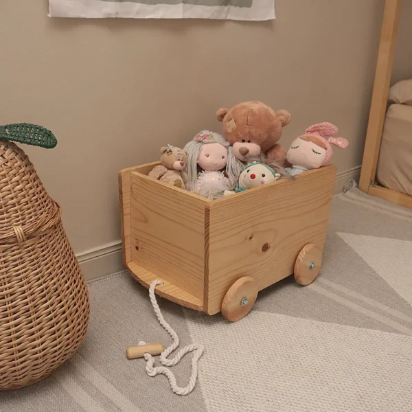 Caja de madera con ruedas tipo carrito de arrastre para guardar juguetes que permite al niño transportar objetos de forma autónoma en su espacio Montessori