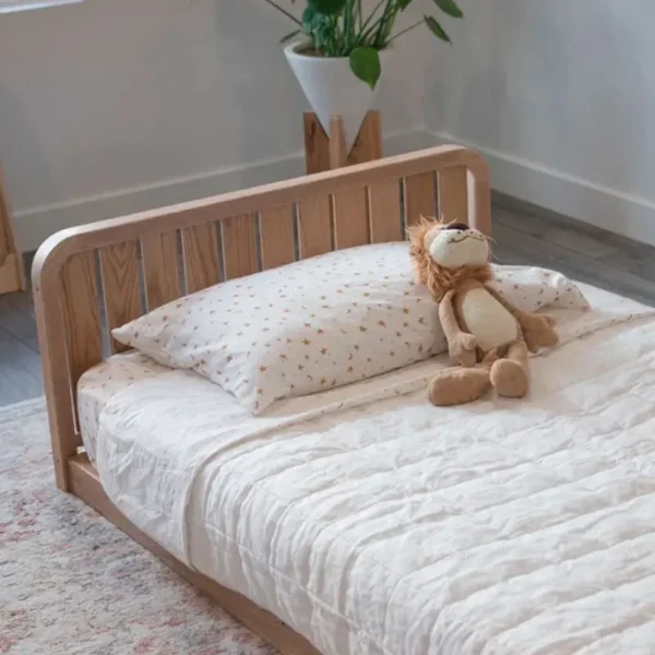 Cama Montessori de madera para bebé con baranda baja que permite subir y bajar de forma autónoma en dormitorio infantil