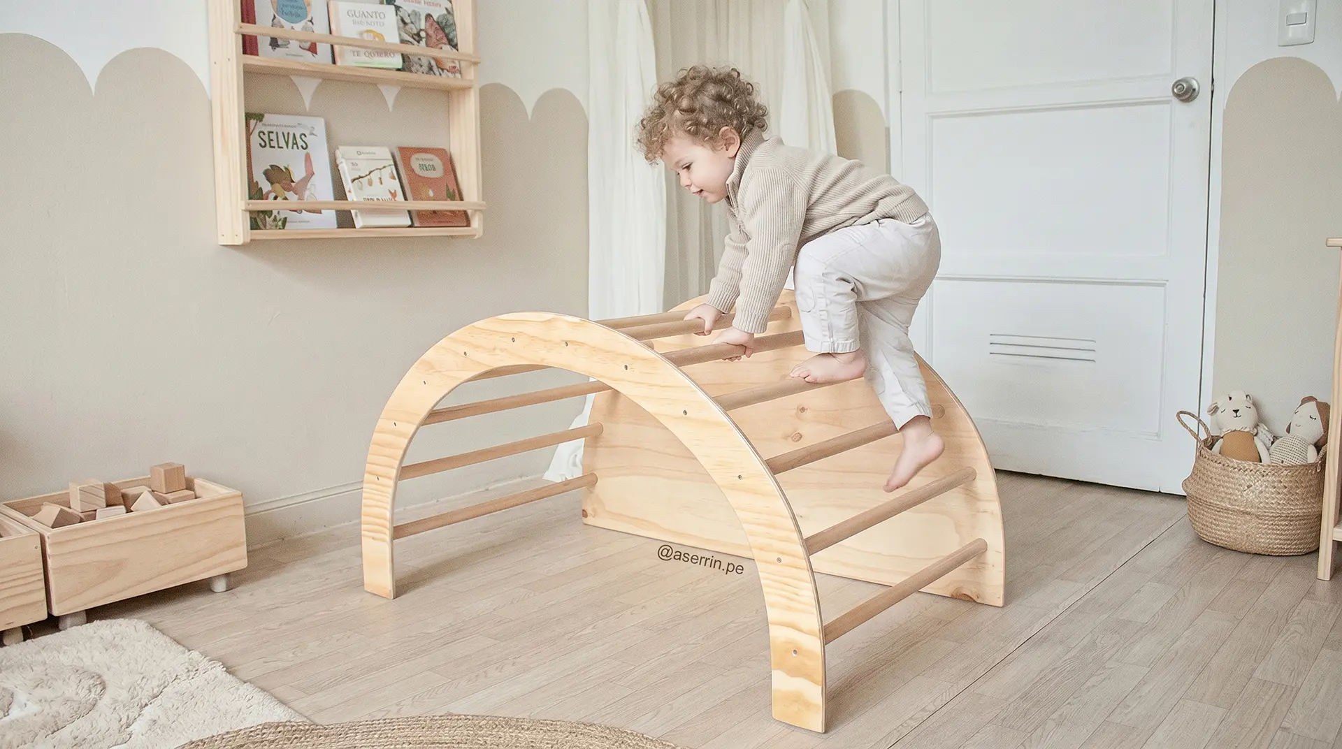 Bebé trepando en arco Pikler de madera en habitación Montessori promoviendo movimiento libre y desarrollo motor temprano