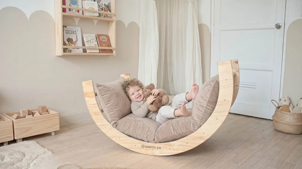 Bebé recostado en balancín Waldorf con puff acolchado en habitación Montessori promoviendo descanso, equilibrio y movimiento libre