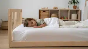 niño pequeño durmiendo en cama baja Montessori promoviendo autonomía y movimiento libre en ambiente preparado