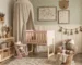 Habitación Montessori para bebé con cuna evolutiva rosa y madera natural, estantería baja, mesa infantil y decoración cálida inspirada en movimiento libre y autonomía temprana.